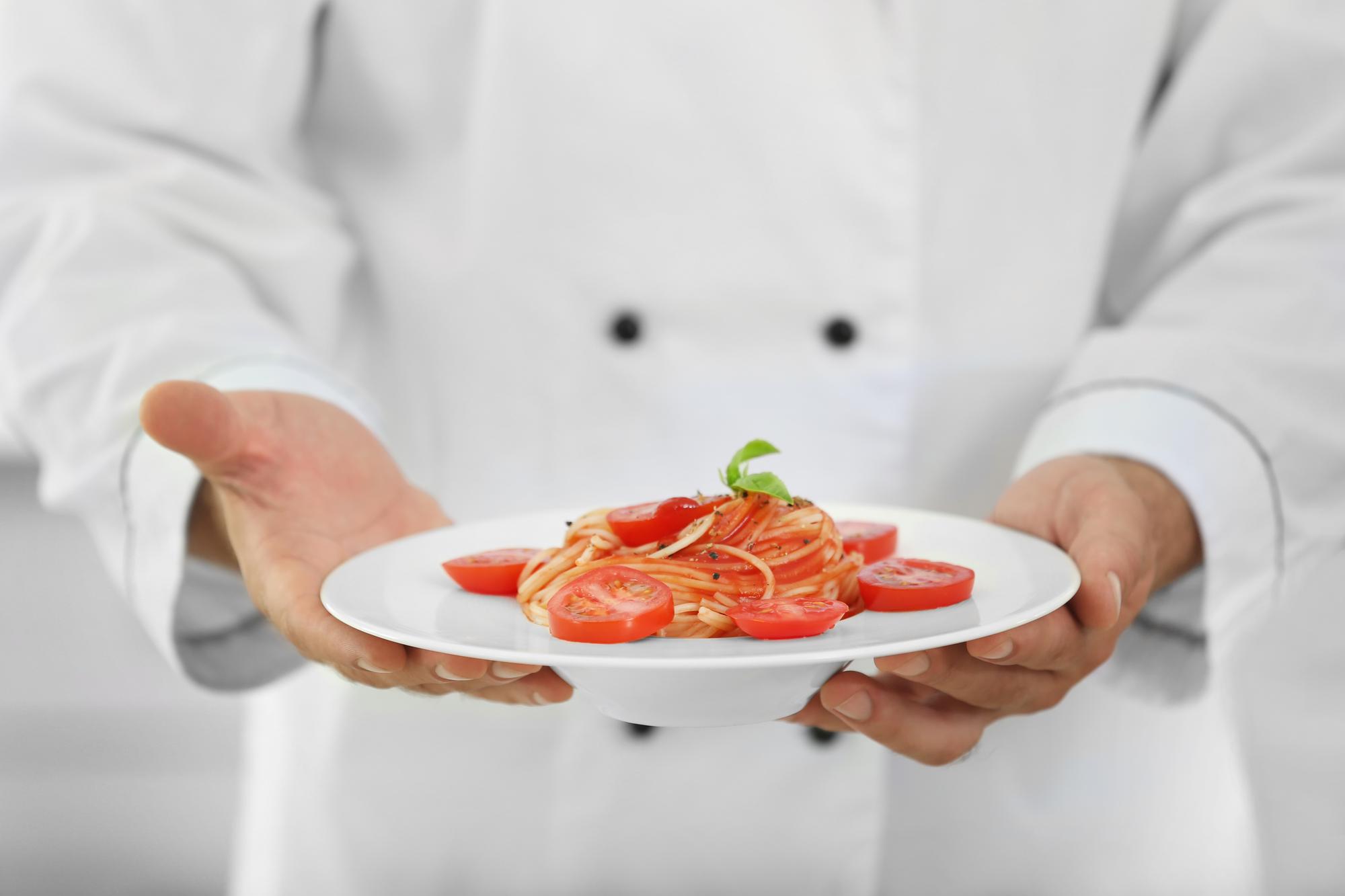 Chef arranging plated dish in workshop